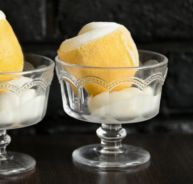 Ice cream sorbet in lemon and glass on dark background