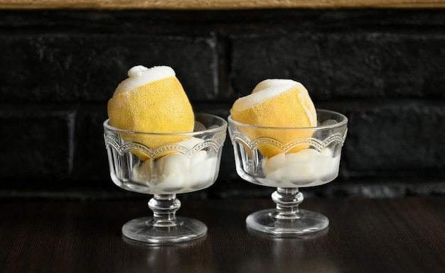 Foto sorbetto di gelato al limone e vetro su sfondo scuro