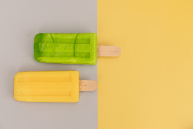 Photo ice cream stick on gray and yellow background.