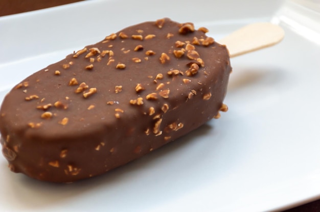 Ice cream on a stick with chocolate icing and nuts