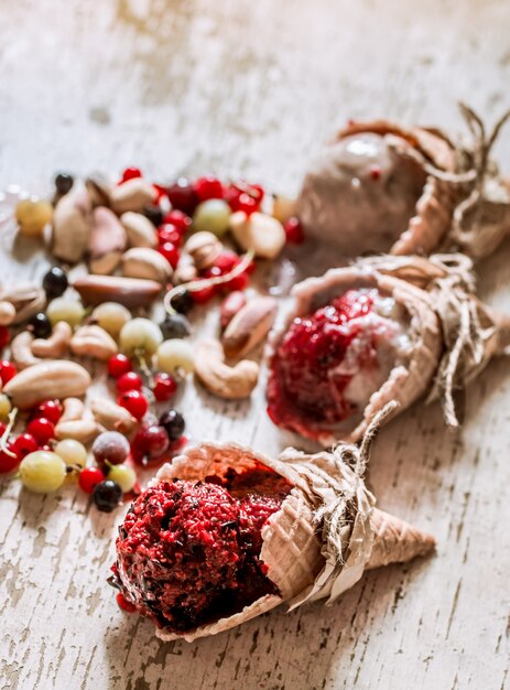 Ice cream waffle cone with berries on wooden table