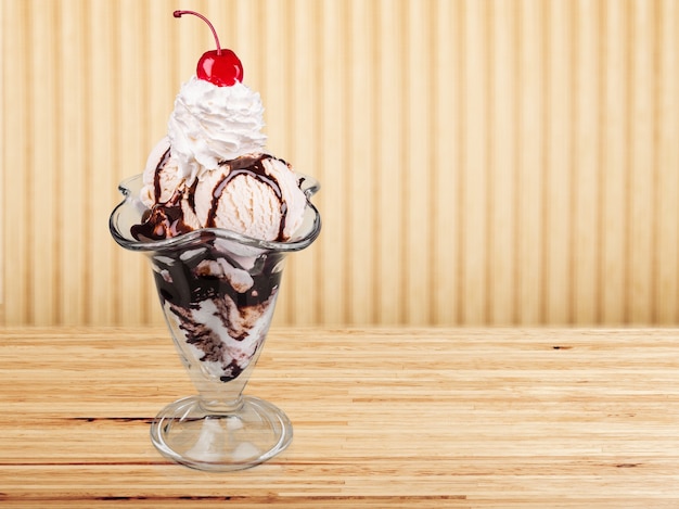 Ice cream with chocolate topping and cherry in glass