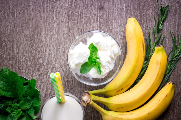 Ice cream with fresh banana and mint on wooden table