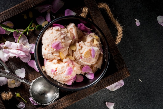 Ice cream with rose petals and slices of almond in white serving bowls