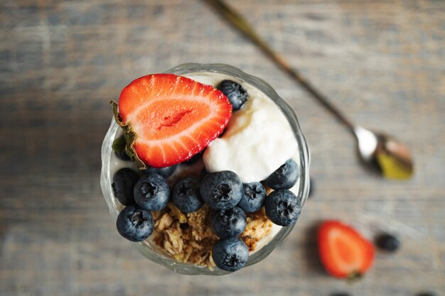 Ice cream with strawberries and blueberries in a tall glass