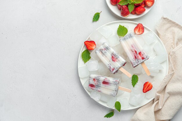 Ice cream with strawberries and chia seeds on a light background