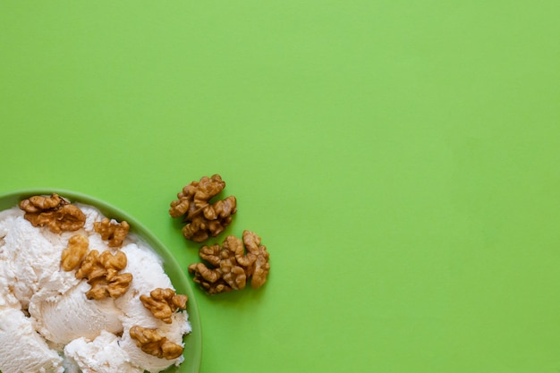 Ice cream with walnut on green plate. copyspace