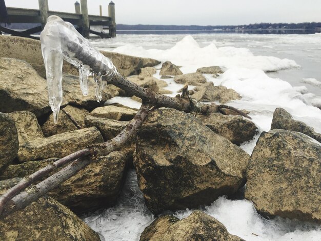 Foto cristalli di ghiaccio sulla spiaggia rocciosa