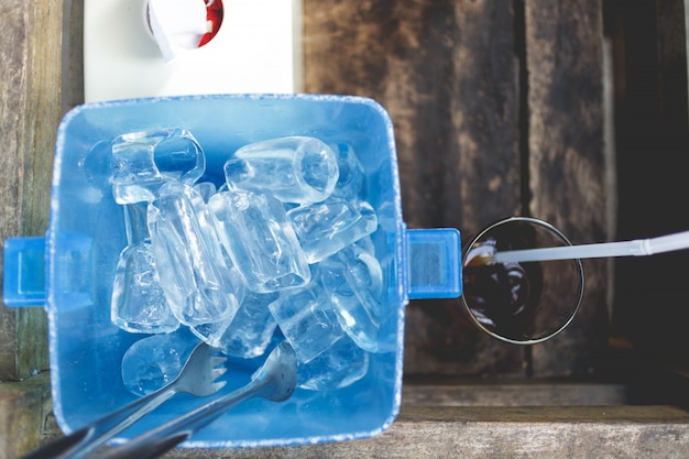 Кубик льда в голубой пластиковой корзине. Тайский ресторан, обслуживающий стиль.
