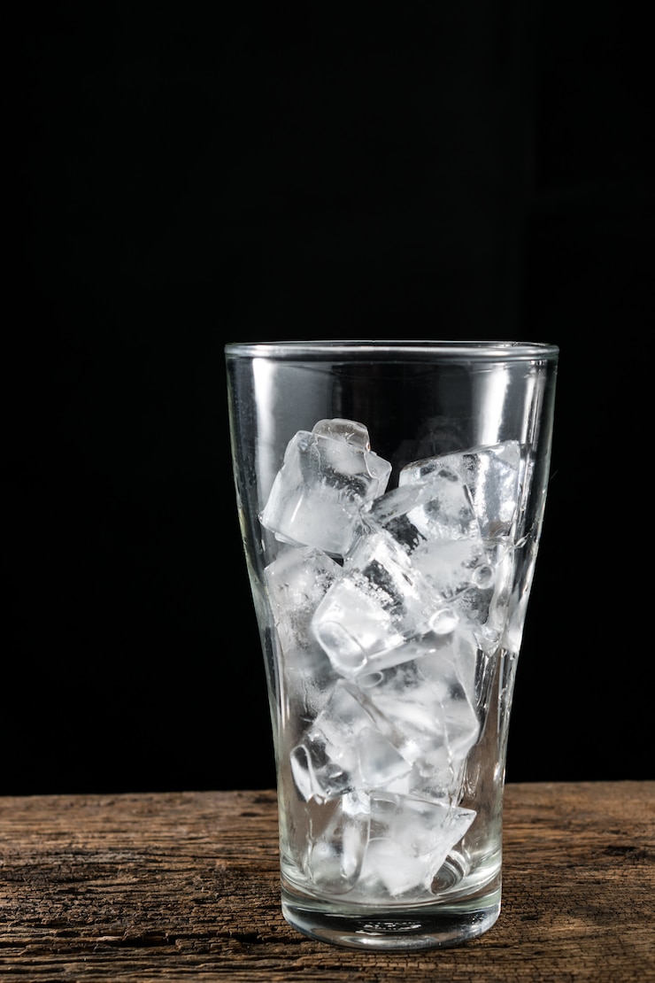 Photo ice cube in glass on wood table