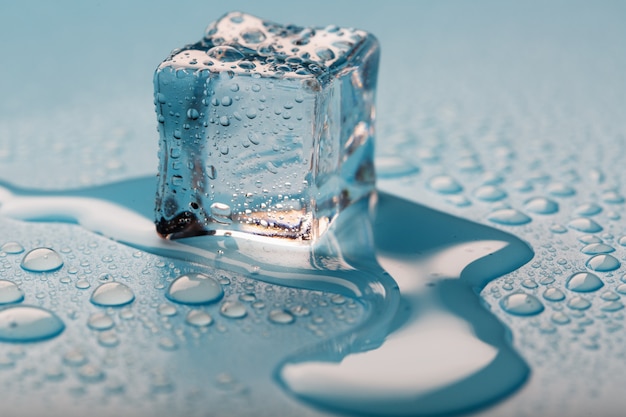 Ice cube with water drops The ice is melting.