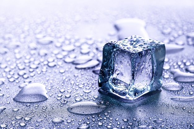 Фото Кубики льда и вода тают на прохладном фоне. ледяные глыбы с холодными напитками или напитками.