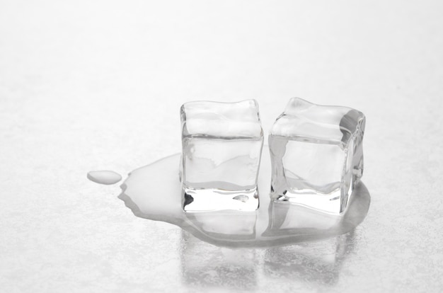 Photo ice cubes are melting on the white surface