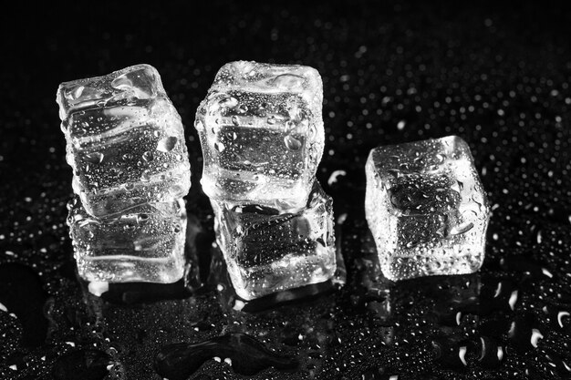 Ice cubes on black table surface.