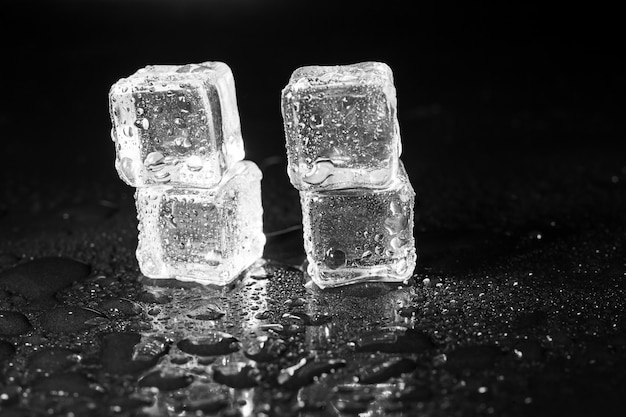 Ice cubes on black table surface.