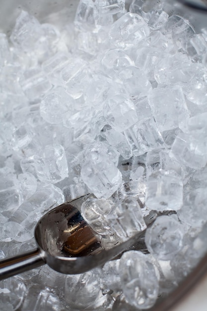 Ice cubes in a bucket. ice shovel. Ice scoop on the ice cubes background, Top view with copy space and text.