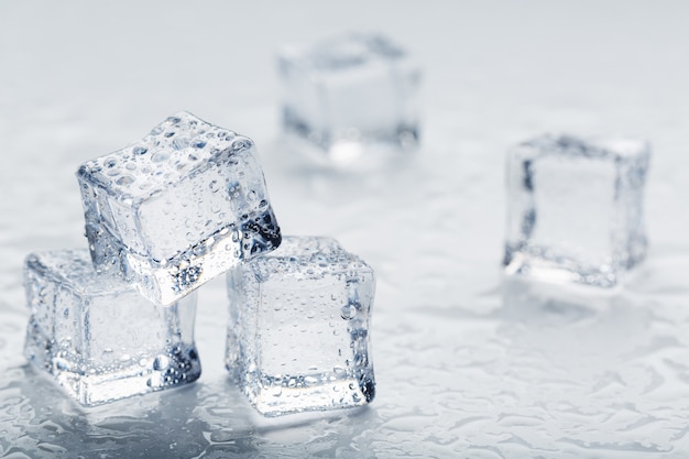 Кубики льда в виде пирамиды с каплями воды крупным планом в макросе