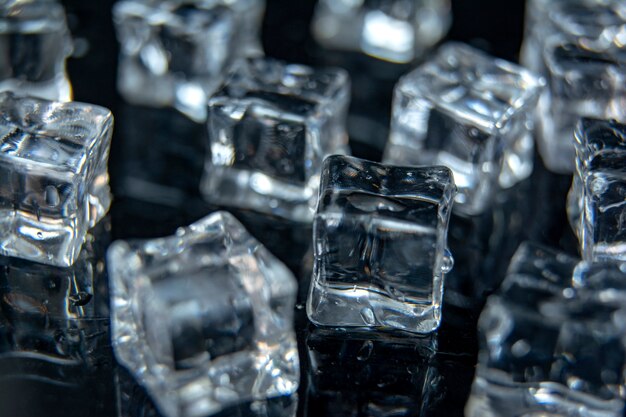 Photo ice cubes / a lot of different ice cubes on reflection table on black background