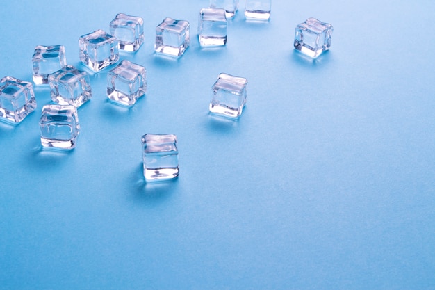 Ice cubes scattered on a light blue background