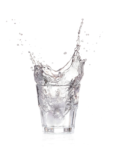 Ice cubes splashing into glass of water, isolated on white