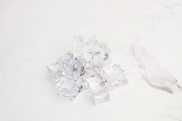 Ice cubes on a white and gray marble table in a top view