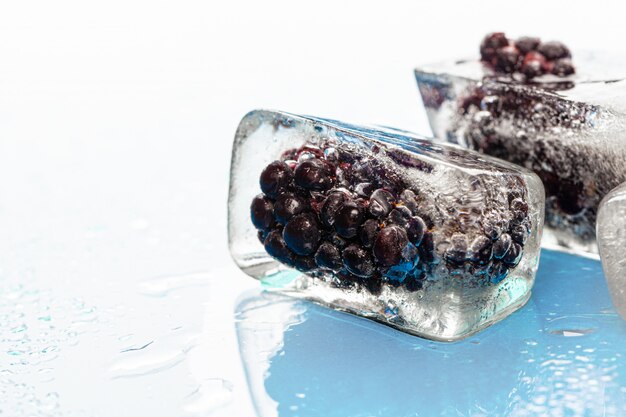 Ice cubes with frozen berries inside close up