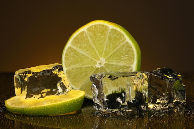 Ice cubes with lime on darck orange background