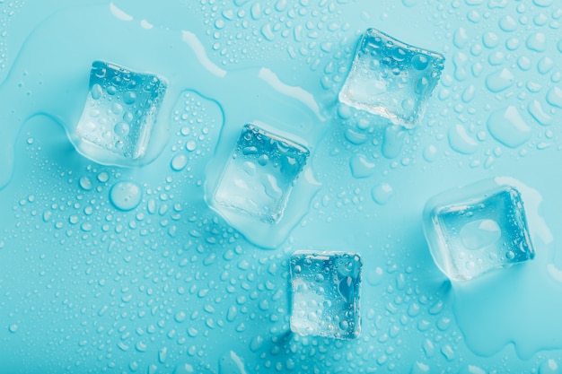 Ice cubes with water drops scattered, top view.