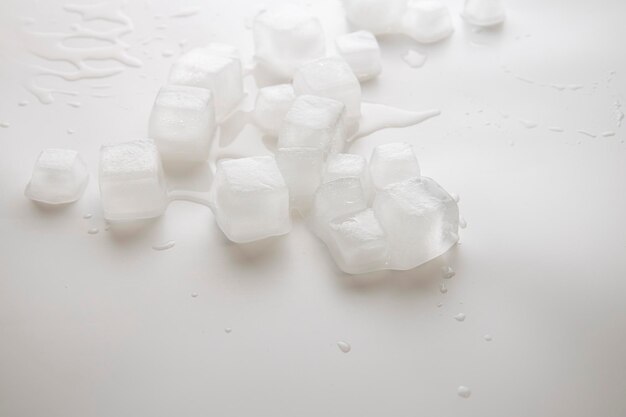 Ice cubes with water drops scattered on a white background Side view