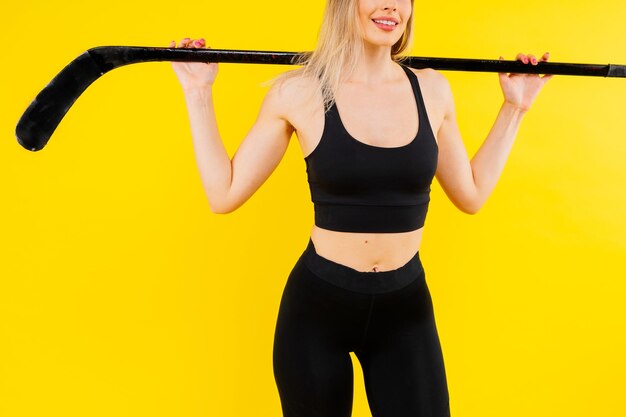 Ice hockey fan female in sports wear with hockey stick in studio