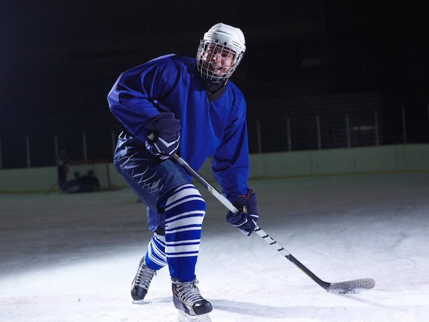 Foto giocatore di hockey su ghiaccio in azione che dà dei calci al bastone