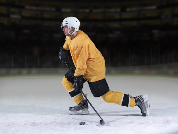 Photo ice hockey player in action kicking with stick