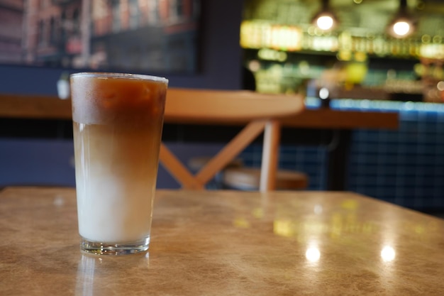 Ice late coffee in a glass on cafe table