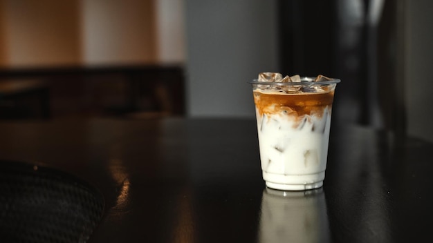 ice latte coffee in plastic glass on black table at cafe