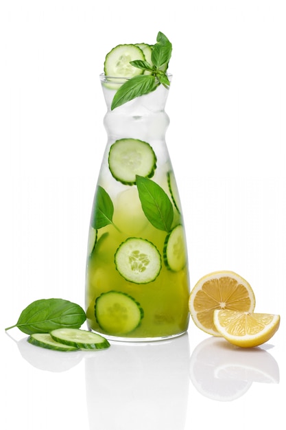 Ice lemonade with cucumber, orange and mint with reflection isolated on white