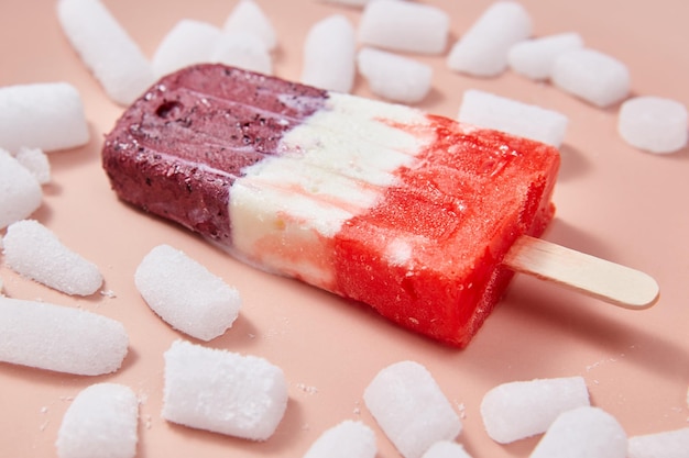 Ice lolly Berry colorful ice cream with ice cubes on a pink background Summer dessert