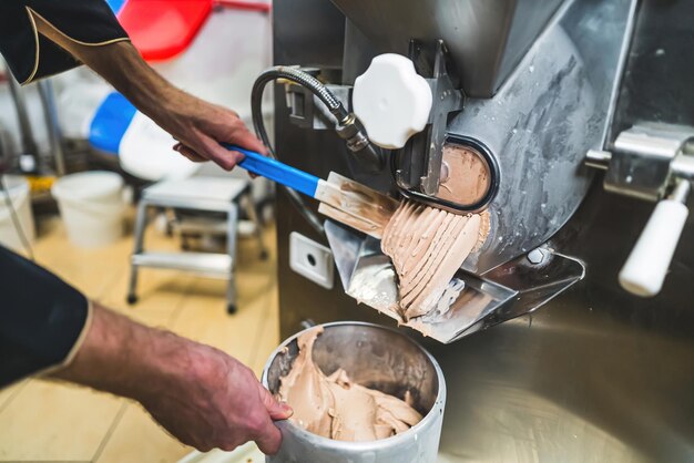 Ice making concept indoors closeup shot of professional worker using ice cream maker and gathering