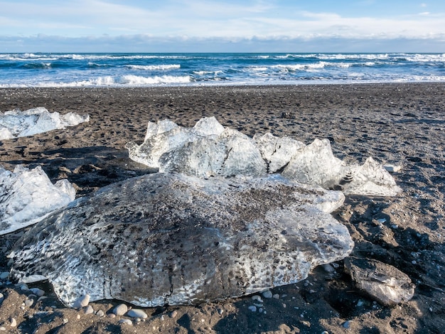 Ice pieces glitter like diamonds on black sand beach in winter season in Iceland