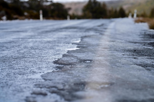 冬の山の道路に氷が張る