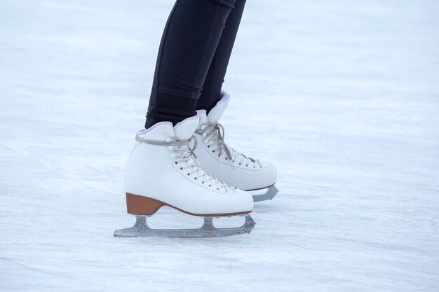 Ice skating on an ice rink. legs with skates. Winter active sport and leisure hobby.