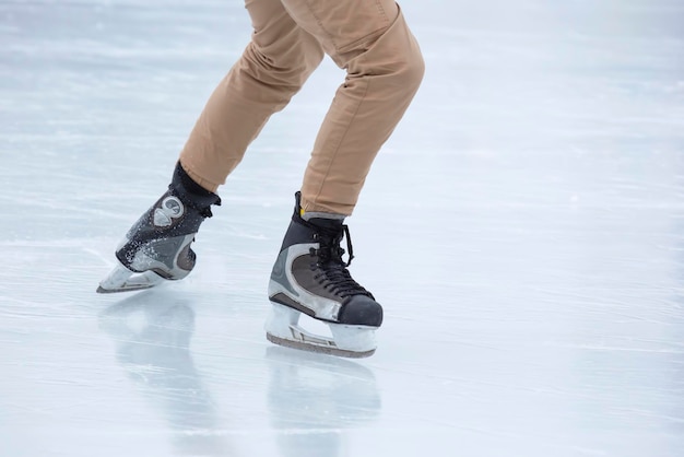 Photo ice skating on an ice rink. legs with skates. winter active sport and leisure hobby.