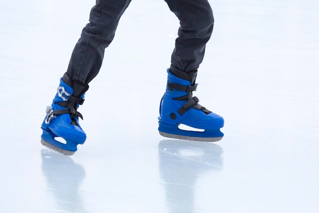 アイススケートリンクでのアイススケート。スケートで足。冬のアクティブなスポーツとレジャーの趣味。