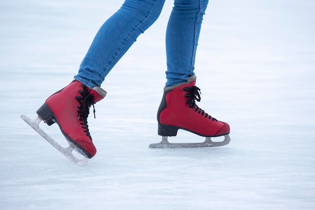 Ice skating on an ice rink. legs with skates. Winter active sport and leisure hobby.