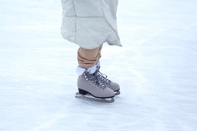 Ice skating on an ice rink. legs with skates. Winter active sport and leisure hobby.