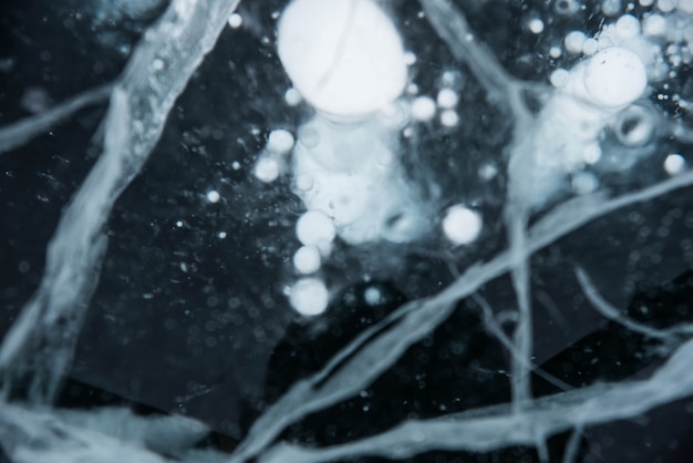 Ice texture close-up. Cracked ice with air and methane bubbles.