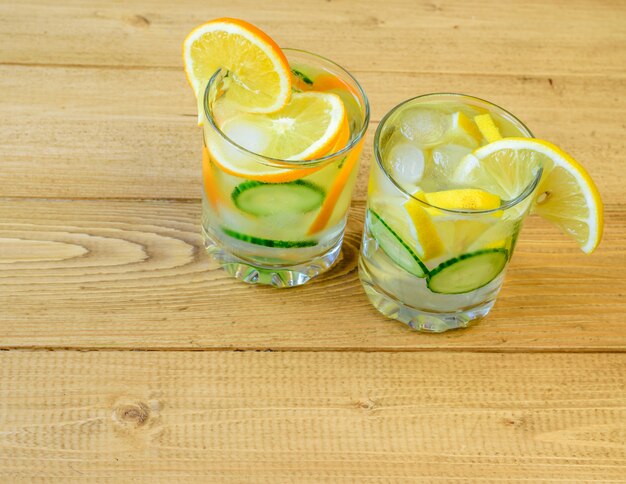 Вода со льдом, лимон, апельсин, корень имбиря и огурец.