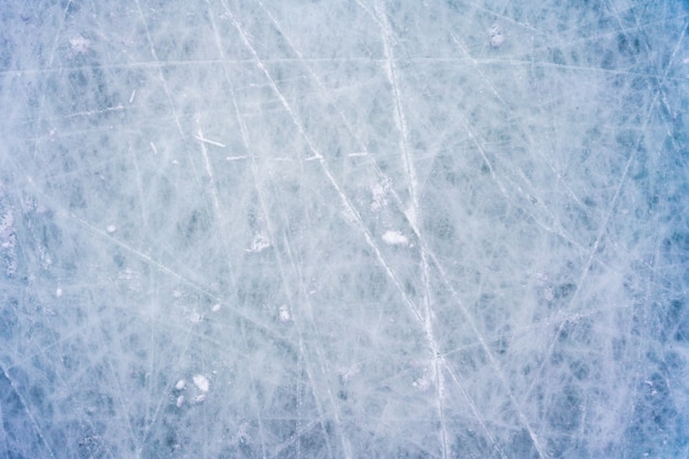 Ghiaccio con segni di pattinaggio e hockey, trama blu della superficie della pista con graffi