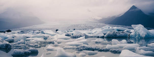 Foto iceberg che galleggia sul fiume vicino alla vetta della montagna