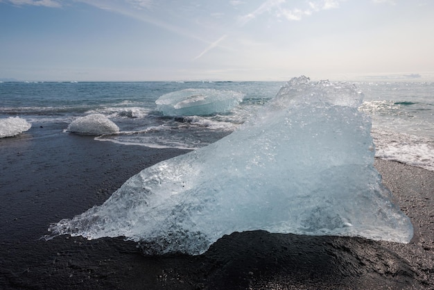 Photo iceberg pieces from a glacier calving on a black sand beach