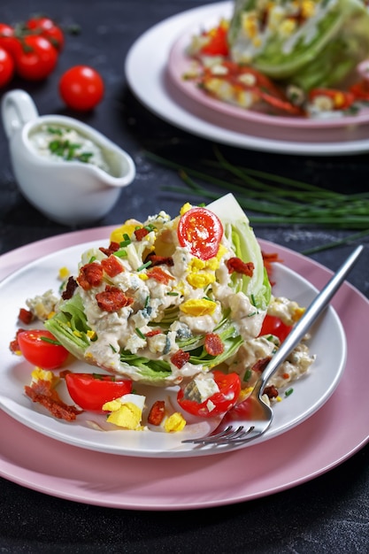 iceberg wedge salad with blue cheese sauce, bacon,  tomatoes, eggs